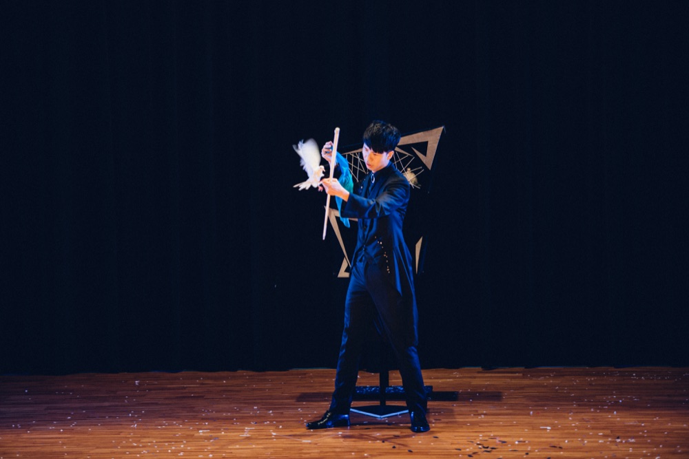 幻影鴿王於舞台中央演出鴿子魔術