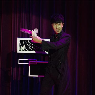 幻影鴿王在舞台道具前手持鴿子演出