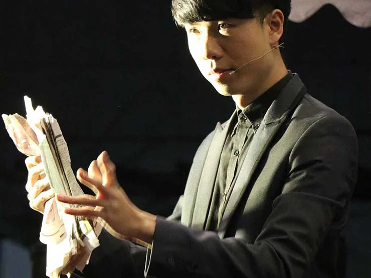 幻影鴿王以報紙道具進行舞台魔術表演