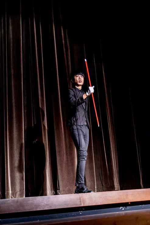 幻影鴿王於紅幕舞台進行魔術表演