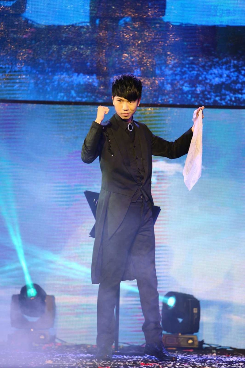 幻影鴿王以白色絲巾進行舞台魔術表演