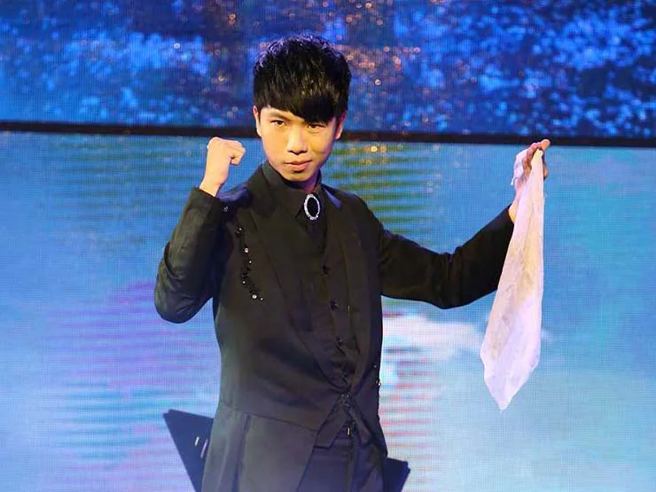 幻影鴿王以白色絲巾進行舞台魔術表演