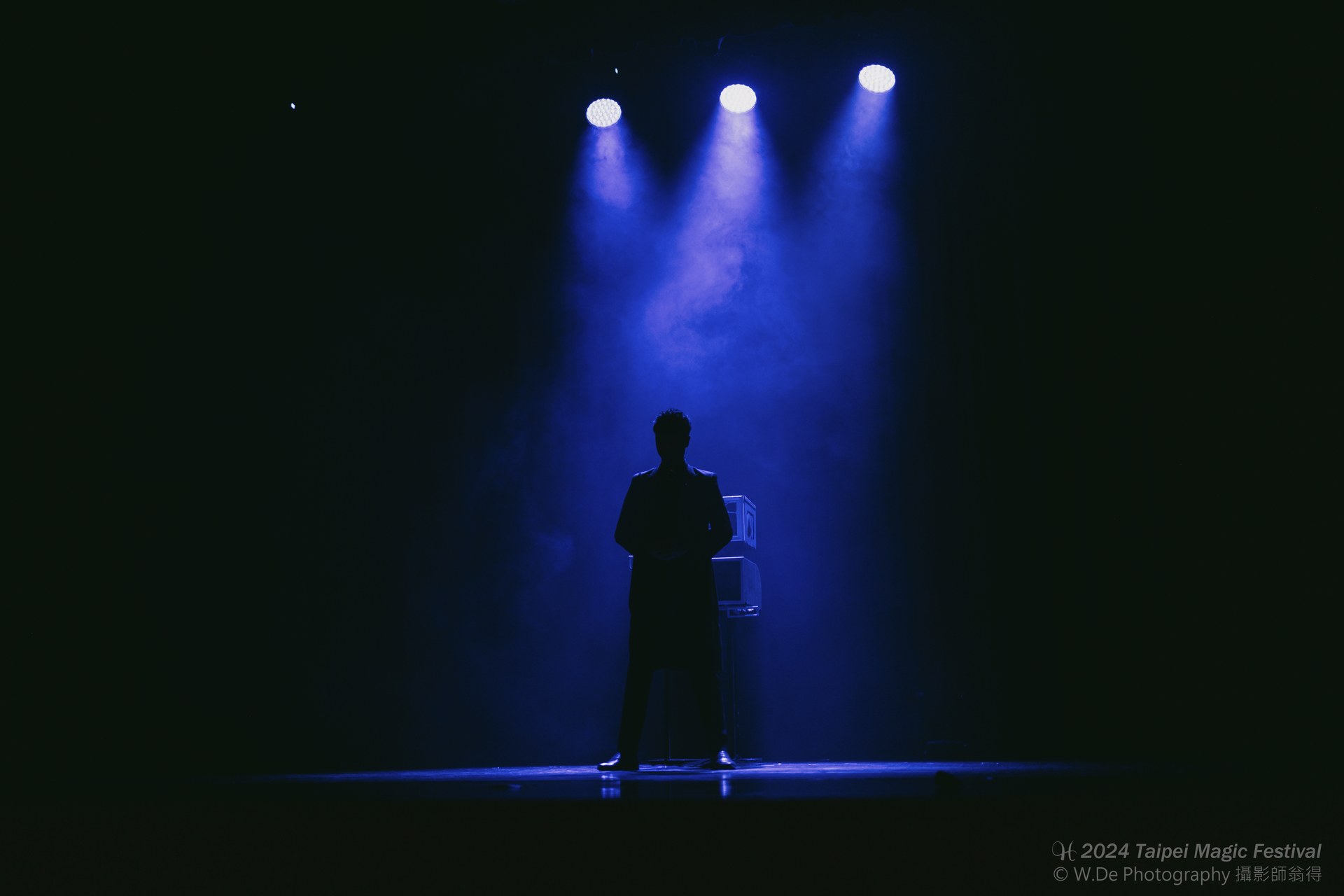 幻影鴿王站在藍色舞台光束下演出《三鴿幻影》